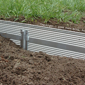Picture of Aluminum edging separating grass from mulched landscaping bed. Available in Black or Bronze.